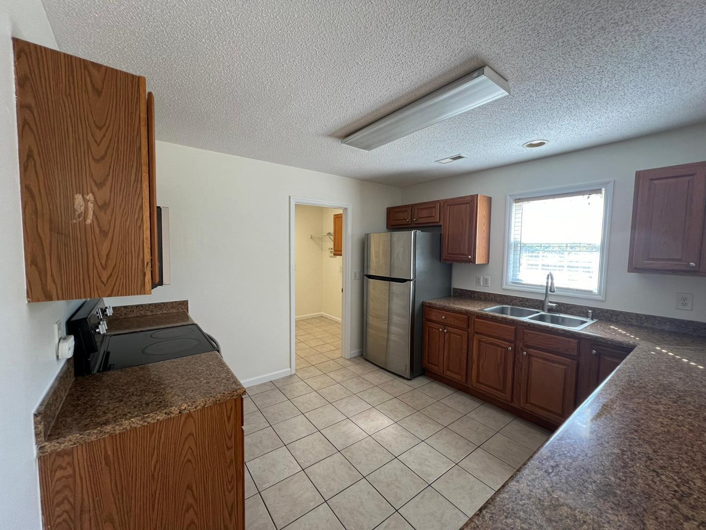 100 Dover Court East Sanford, NC 27332 - Photo 4 of 20 a kitchen with granite countertop a refrigerator and a stove top oven