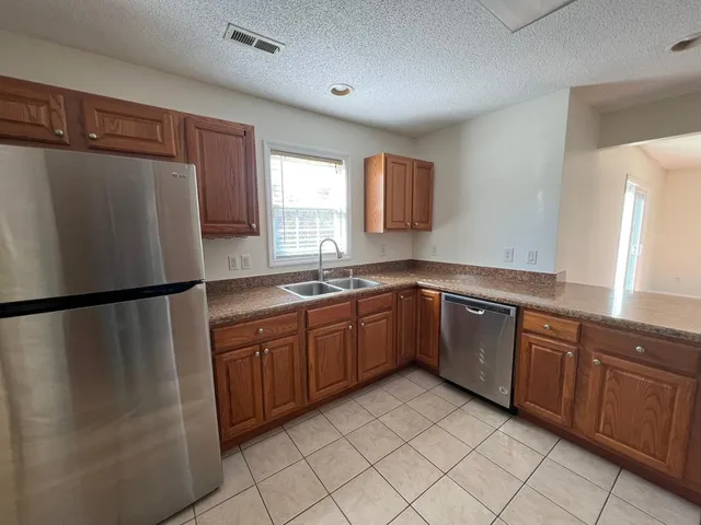 a kitchen with stainless steel appliances granite countertop a refrigerator sink and cabinets