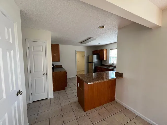 a view of a kitchen with an empty space and a window