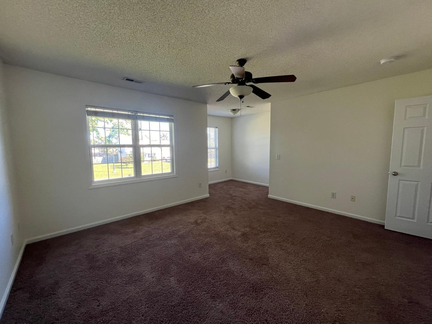 100 Dover Court East Sanford, NC 27332 - Photo 9 of 20 an empty room with windows and a ceiling fan