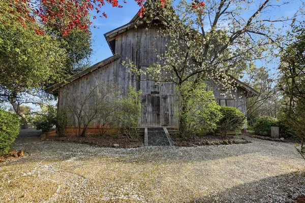 a house is sitting in middle of the forest