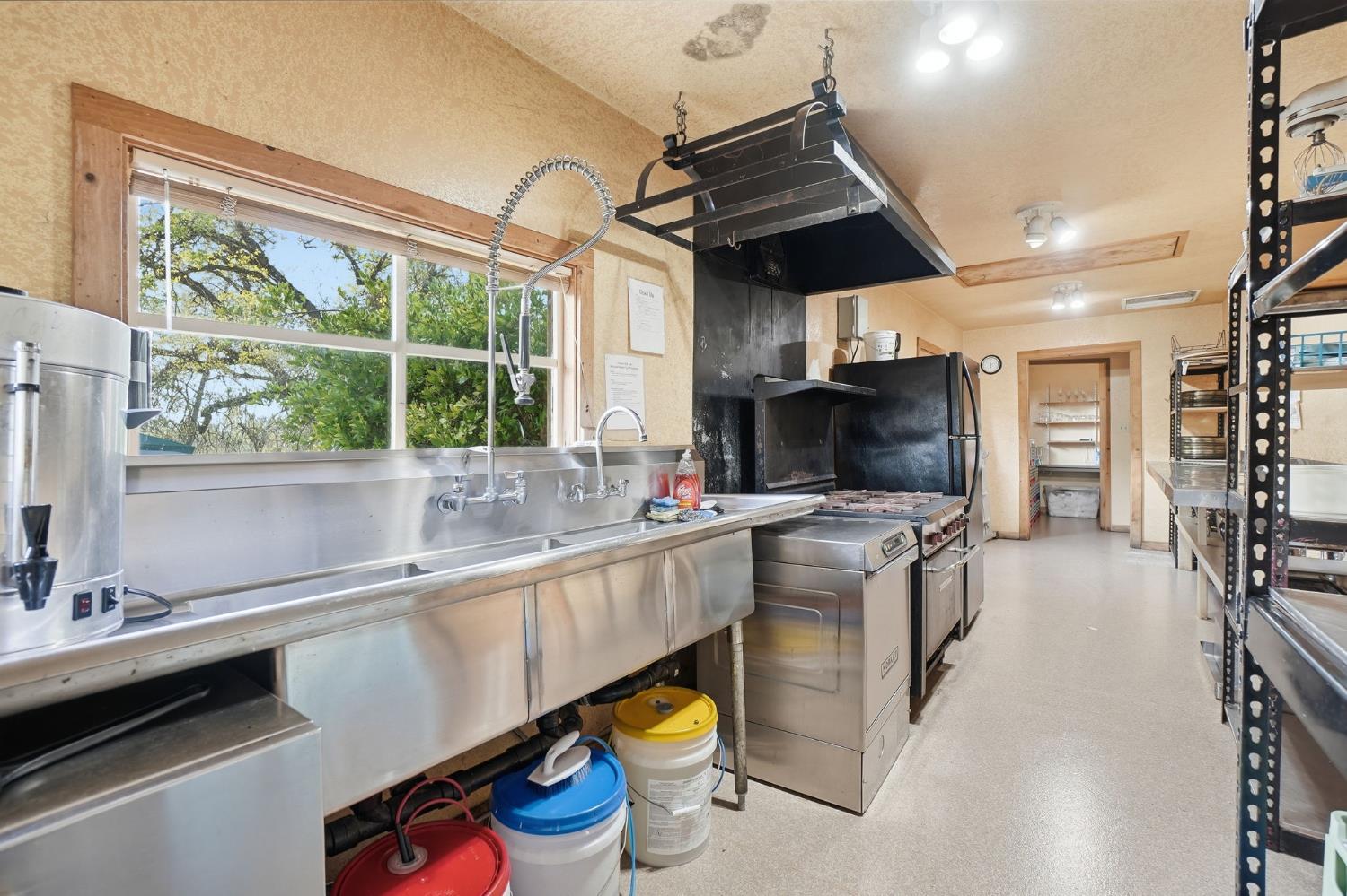 21645 Parrotts Ferry Road Sonora, CA 95370 - Photo 57 of 95 a kitchen with stainless steel appliances granite countertop a sink a stove and a wooden floors