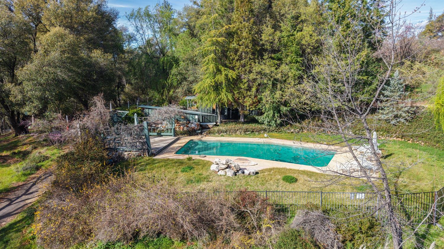 21645 Parrotts Ferry Road Sonora, CA 95370 - Photo 92 of 95 a view of a swimming pool with a yard and large trees