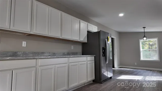 a kitchen with stainless steel appliances granite countertop a refrigerator and cabinets