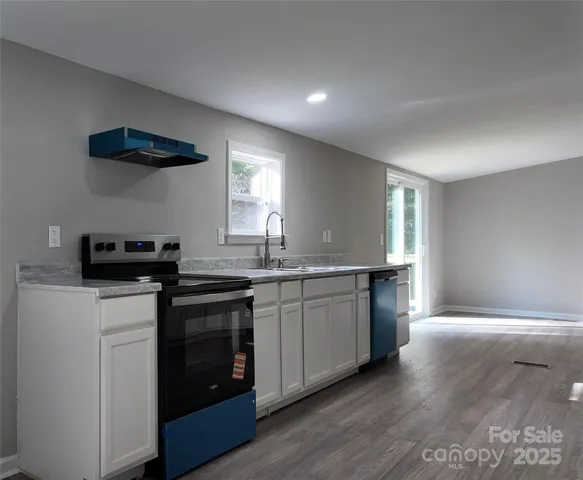 a kitchen with stainless steel appliances granite countertop a stove a sink and a refrigerator