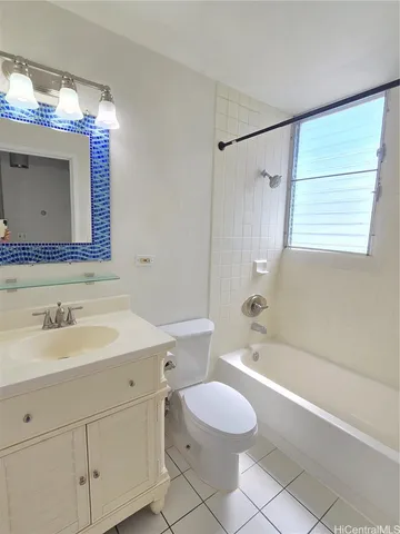a bathroom with a bathtub shower sink vanity mirror and toilet