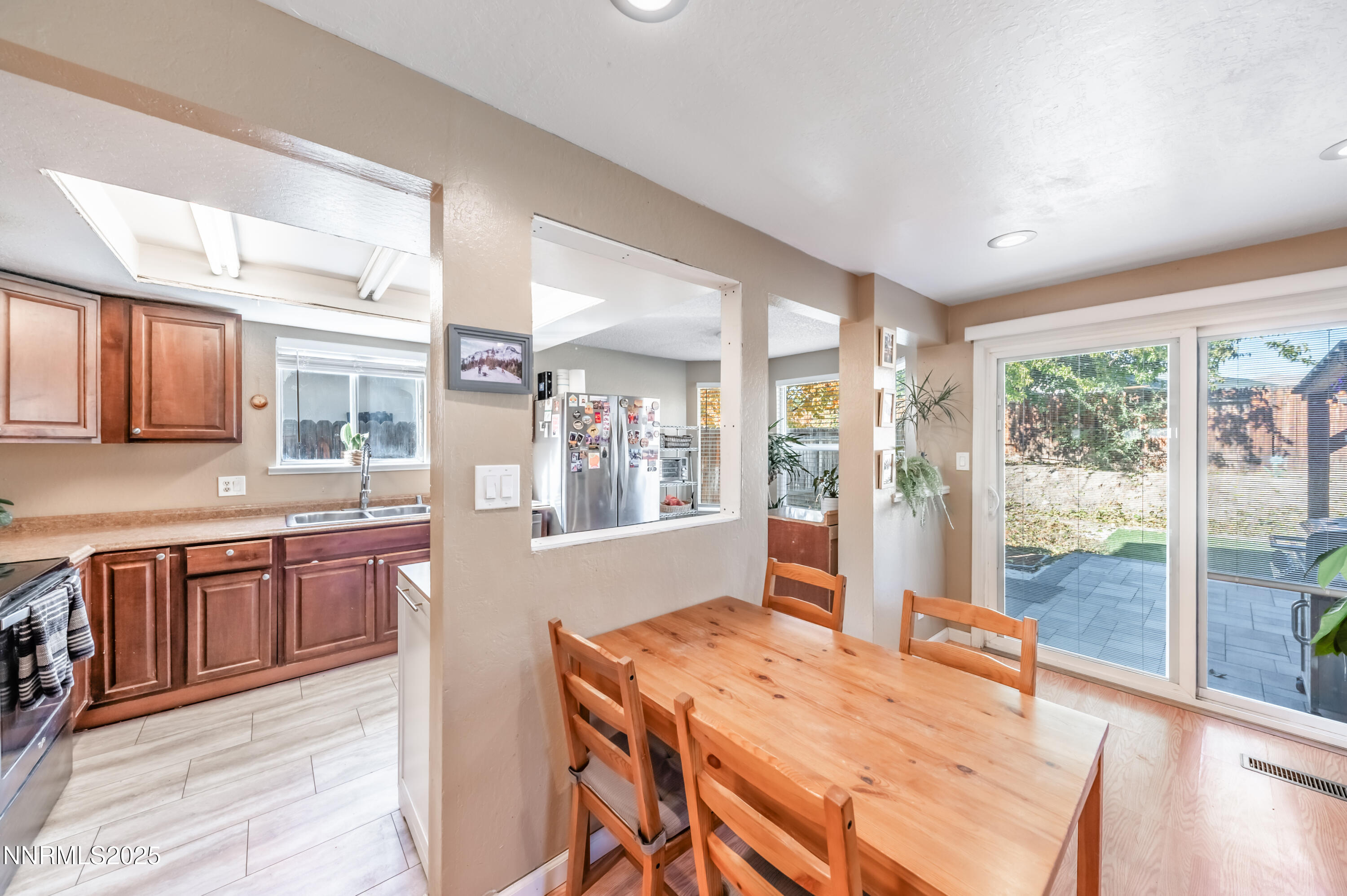 1185 Westlake Road Reno, NV 89523 - Photo 11 of 26 a open kitchen with stainless steel appliances granite countertop a stove a refrigerator a sink dishwasher with a dining table and chairs with wooden floor