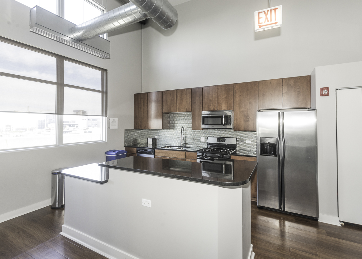 901 West Madison Street, Unit 818 Chicago, IL 60607 - Photo 22 of 26 a kitchen with stainless steel appliances granite countertop a refrigerator a sink a stove and island with wooden floors