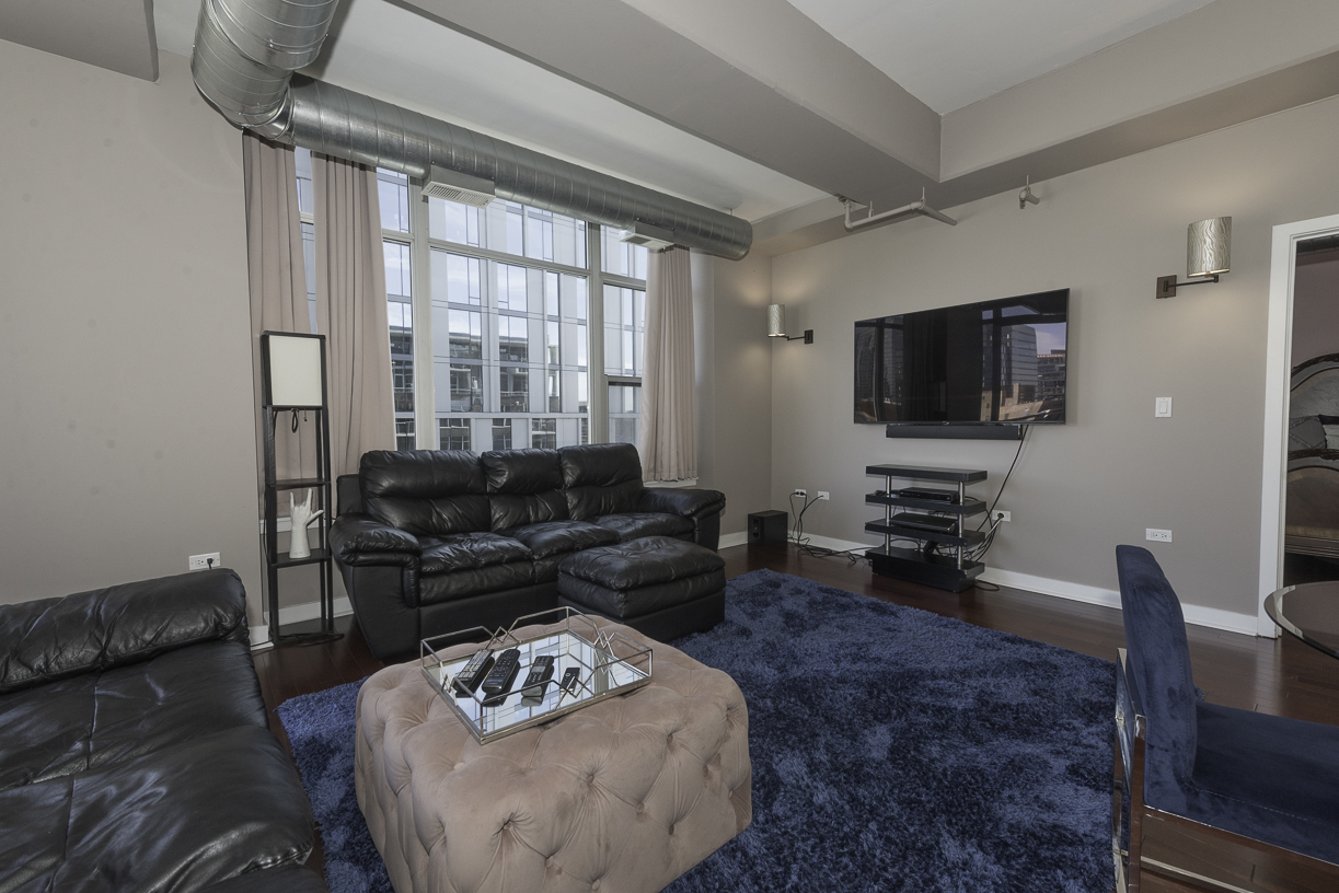 901 West Madison Street, Unit 818 Chicago, IL 60607 - Photo 3 of 26 a living room with furniture and a flat screen tv
