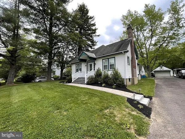 a front view of a house with a yard and trees