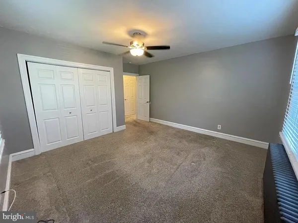 a view of an empty room with a chandelier fan