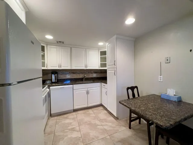 a kitchen with a table chairs sink and cabinets