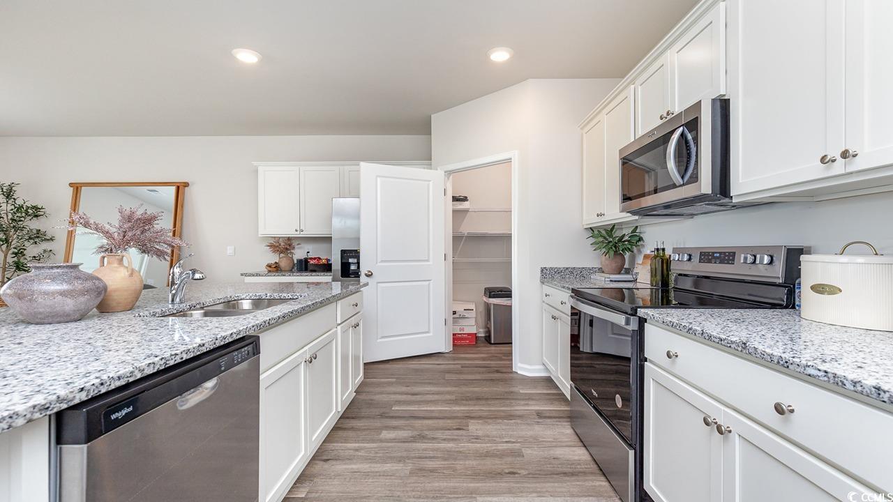 886 Farmers Passage Loop Loris, SC 29569 - Photo 3 of 24 Kitchen featuring a sink, white cabinetry, light s