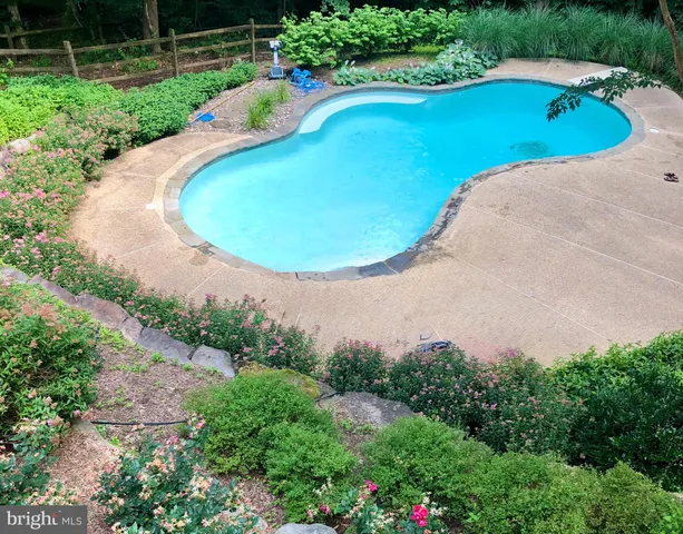 a view of a swimming pool in he middle of the green field