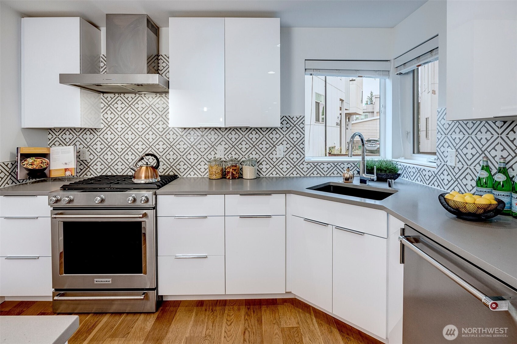 4274 Northeast 50th Street Seattle, WA 98105 - Photo 8 of 22 a kitchen with stainless steel appliances white cabinets a stove a sink and a potted plant