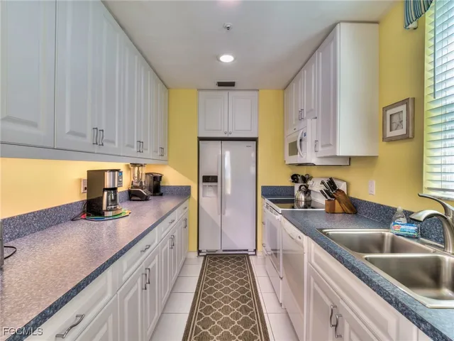 a kitchen with kitchen island granite countertop a sink stainless steel appliances and cabinets