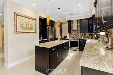 a kitchen with stainless steel appliances granite countertop a stove a sink and a refrigerator