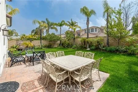 a view of a patio with table and chairs potted plants and palm trees