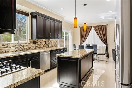 25724 Lewis Way Stevenson Ranch, CA 91381 - Photo 10 of 36 a kitchen with granite countertop a sink a stove and a wooden cabinets