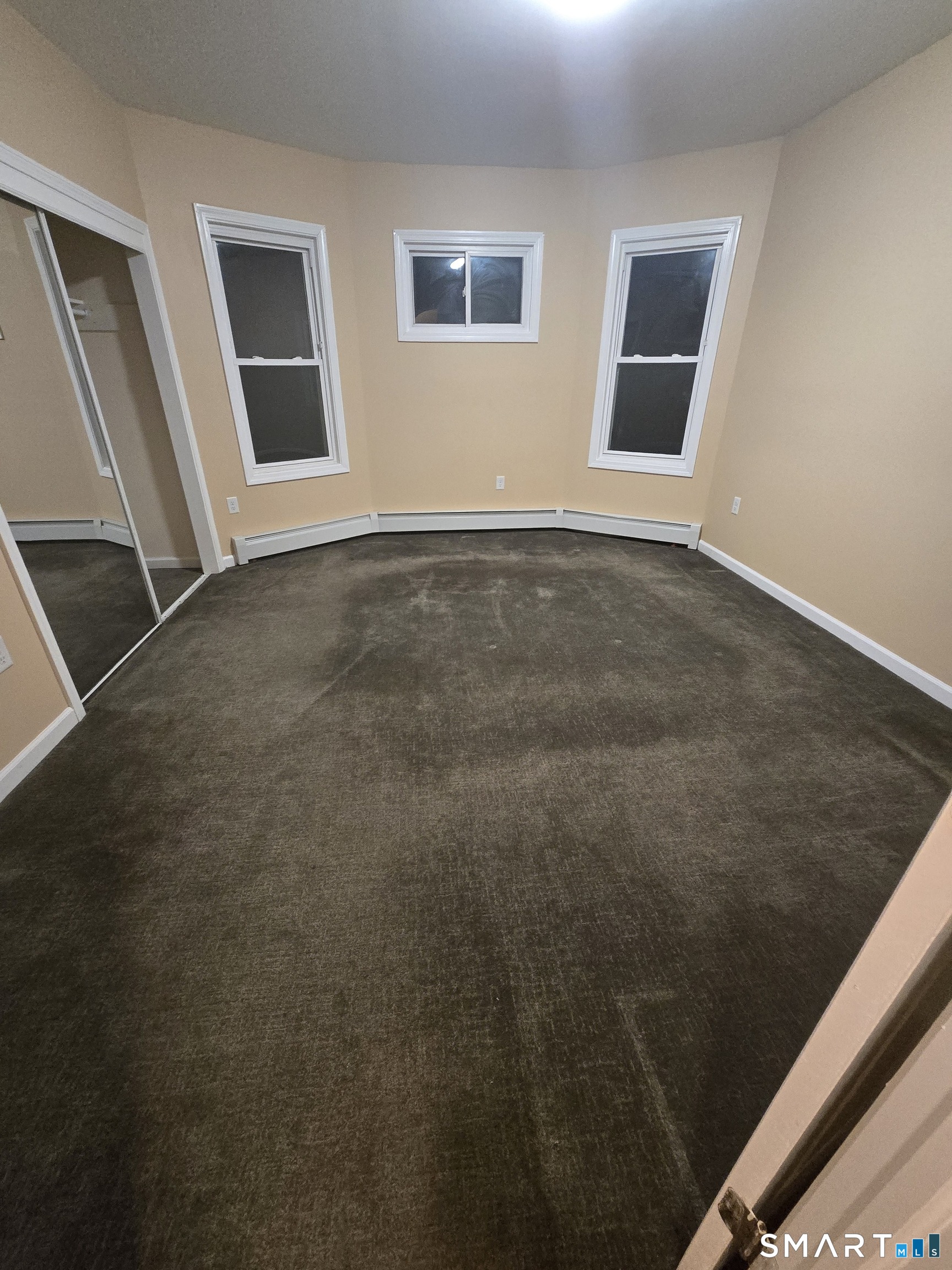 38 Burton Street Hartford, CT 06112 - Photo 5 of 18 a view of an empty room with wooden floor and a window