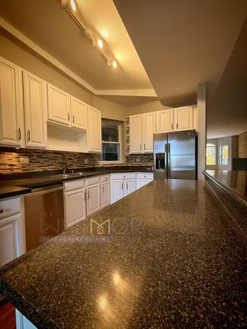 a kitchen with stainless steel appliances granite countertop a stove a sink and a microwave