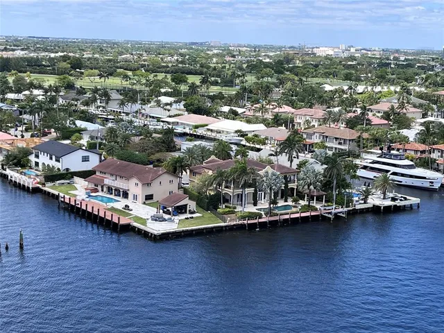a view of a swimming pool with lawn chairs and plants