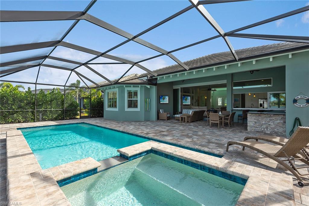 6391 Warwick Avenue Naples, FL 34113 - Photo 21 of 26 a view of a backyard with table and chairs under an umbrella