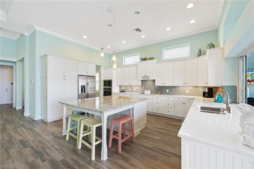 6391 Warwick Avenue Naples, FL 34113 - Photo 9 of 26 a large white kitchen with lots of counter top space and stainless steel appliances