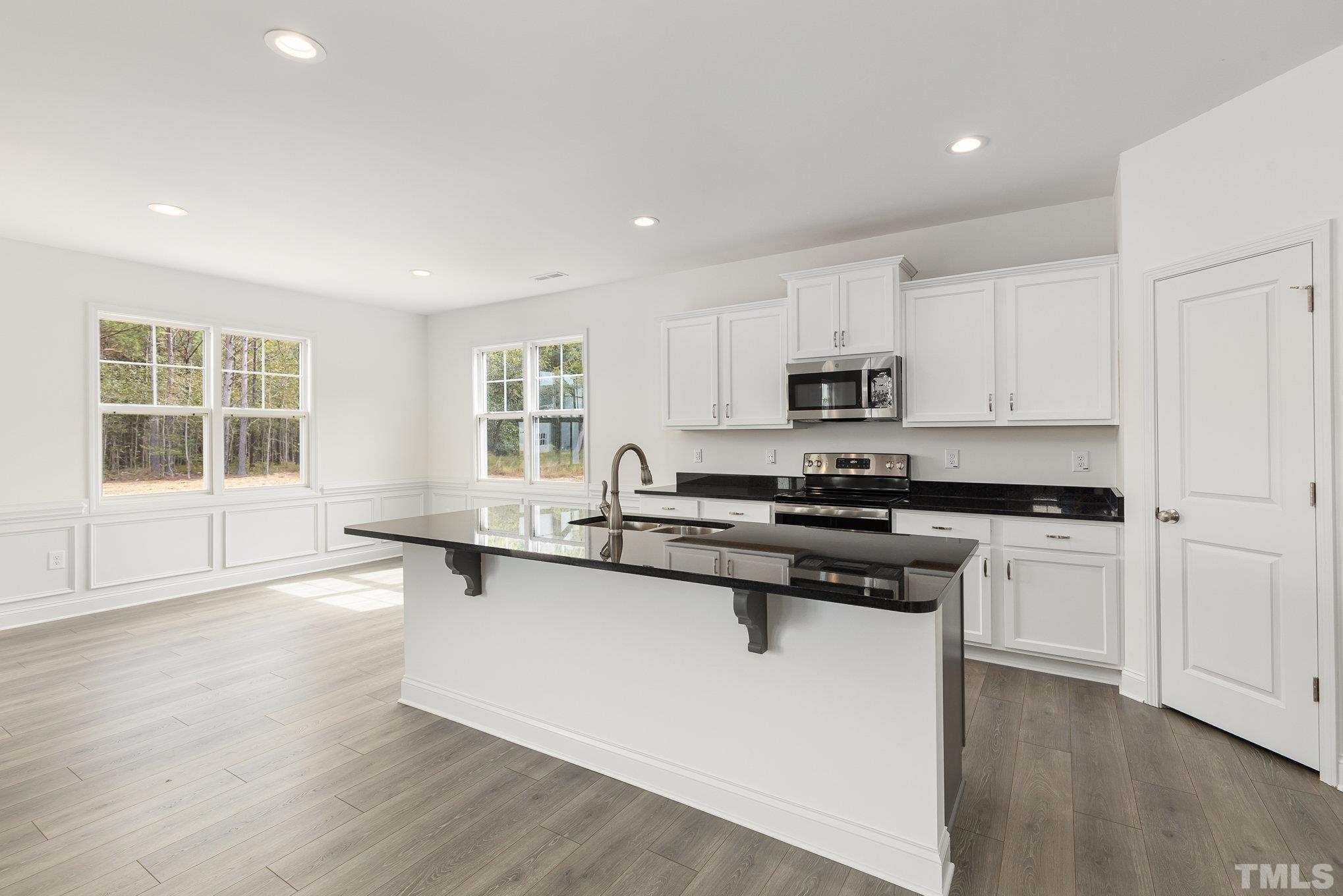 29 Bonnybrook Selma, NC 27576 - Photo 11 of 28 a kitchen with stainless steel appliances granite countertop a stove a sink and a microwave