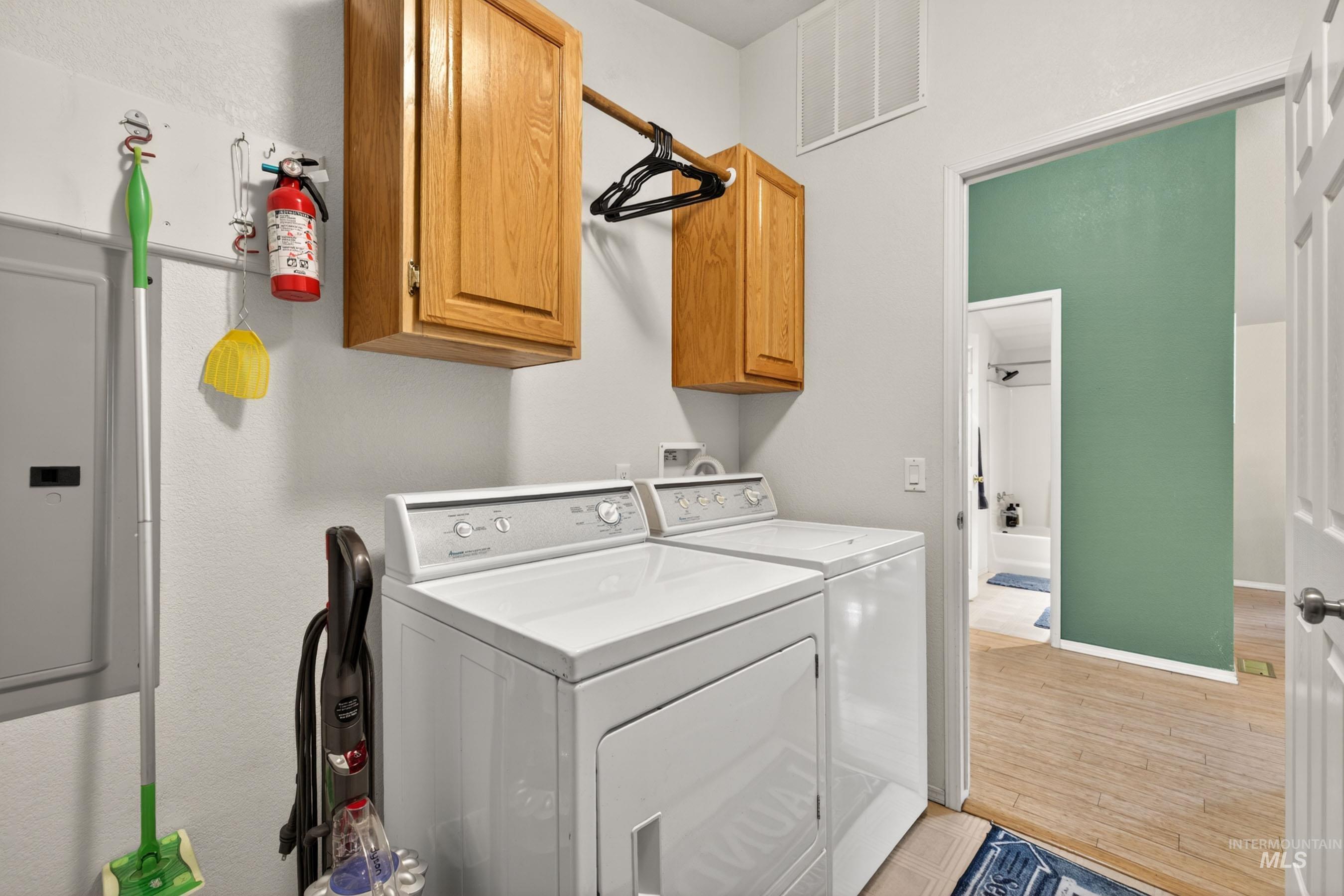 151 Cow Creek Road Lucile, ID 83542 - Photo 36 of 50 Dedicated laundry area featuring overhead wood-finish cabinetry and a clothes hanging rod
