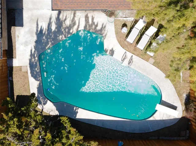an aerial view of a house with a yard and large tree