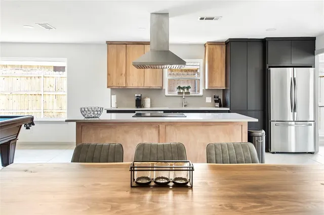 a kitchen with a stove a table and chairs in it