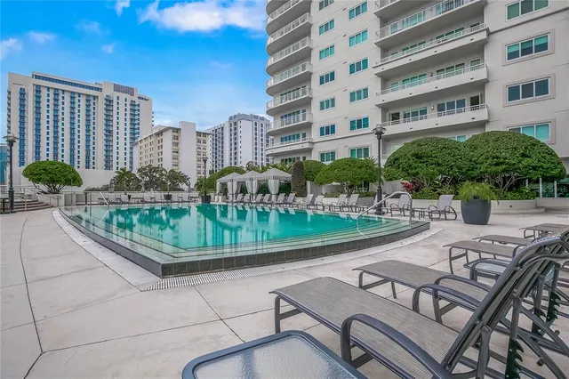 a view of a swimming pool with outdoor seating and plants