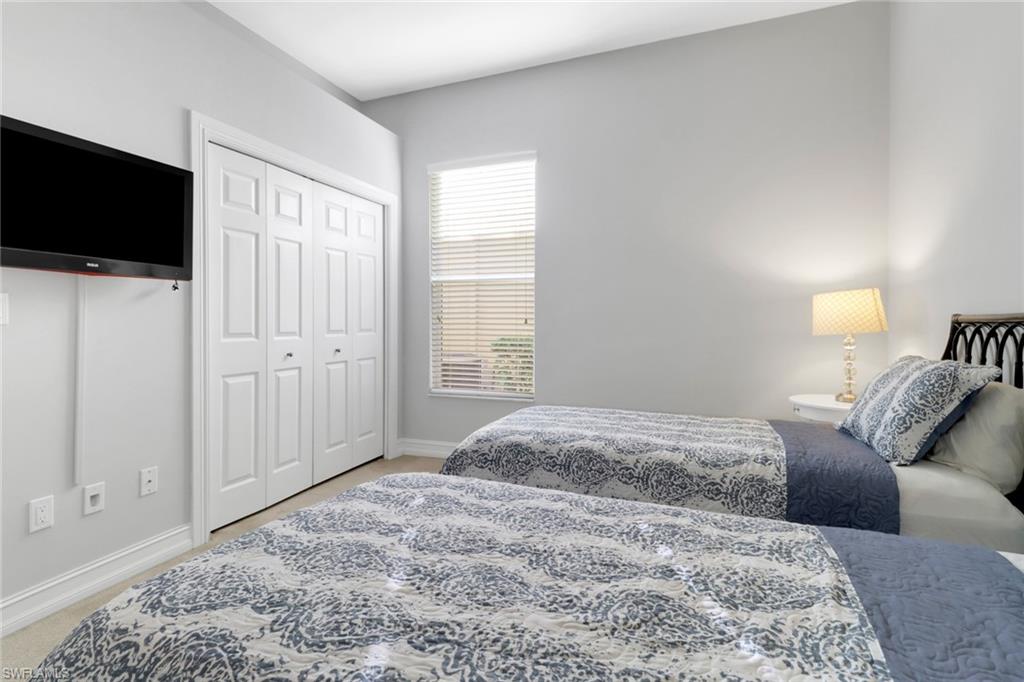 6757 Bent Grass Drive Naples, FL 34113 - Photo 20 of 27 a bedroom with a bed and a flat screen tv