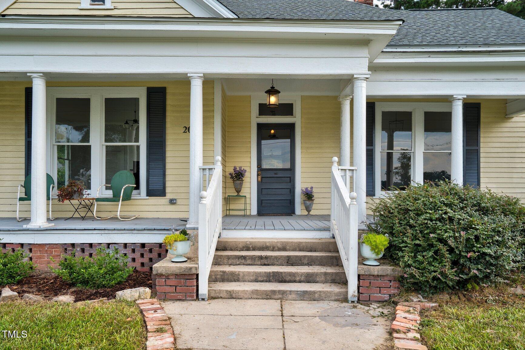 206 West Blalock Road Lucama, NC 27851 - Photo 4 of 35 a front view of a house with potted plants and windows