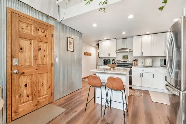 a kitchen with stainless steel appliances granite countertop a refrigerator and a stove top oven