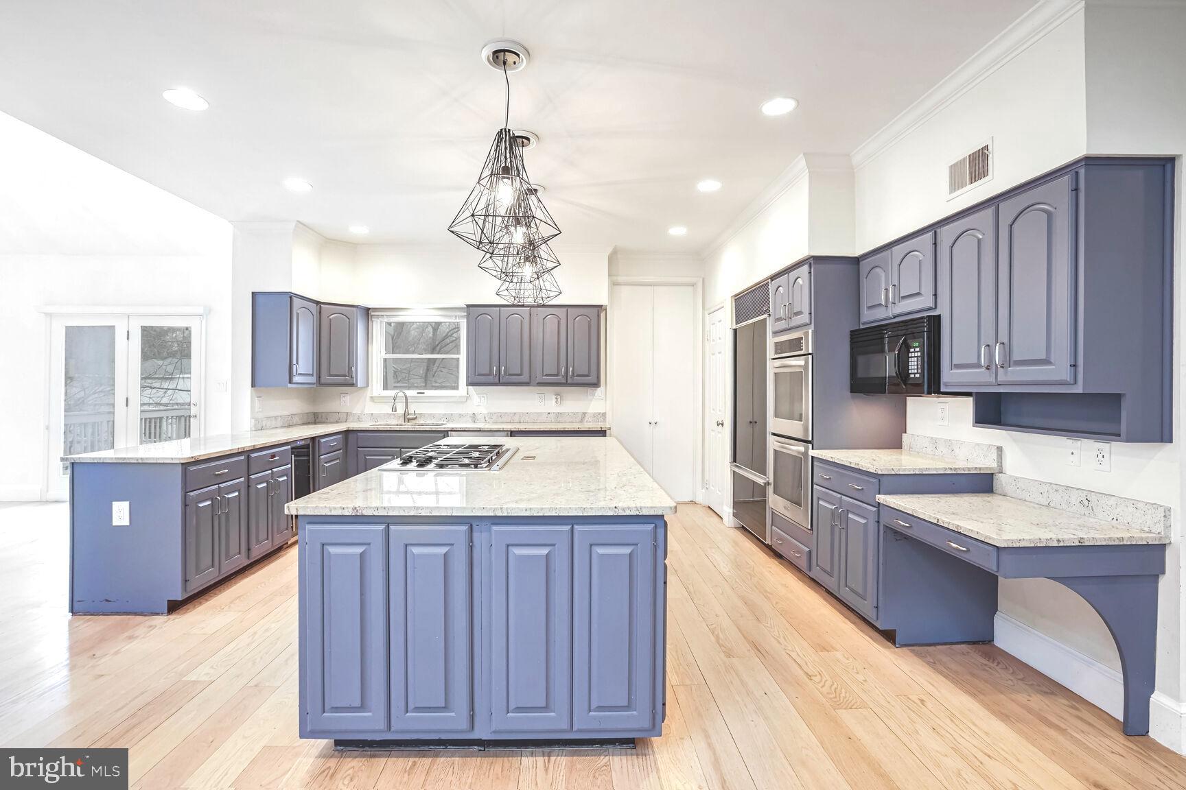 1222 Ranleigh Road McLean, VA 22101 - Photo 13 of 49 a kitchen with a stove a sink a center island and wooden cabinets
