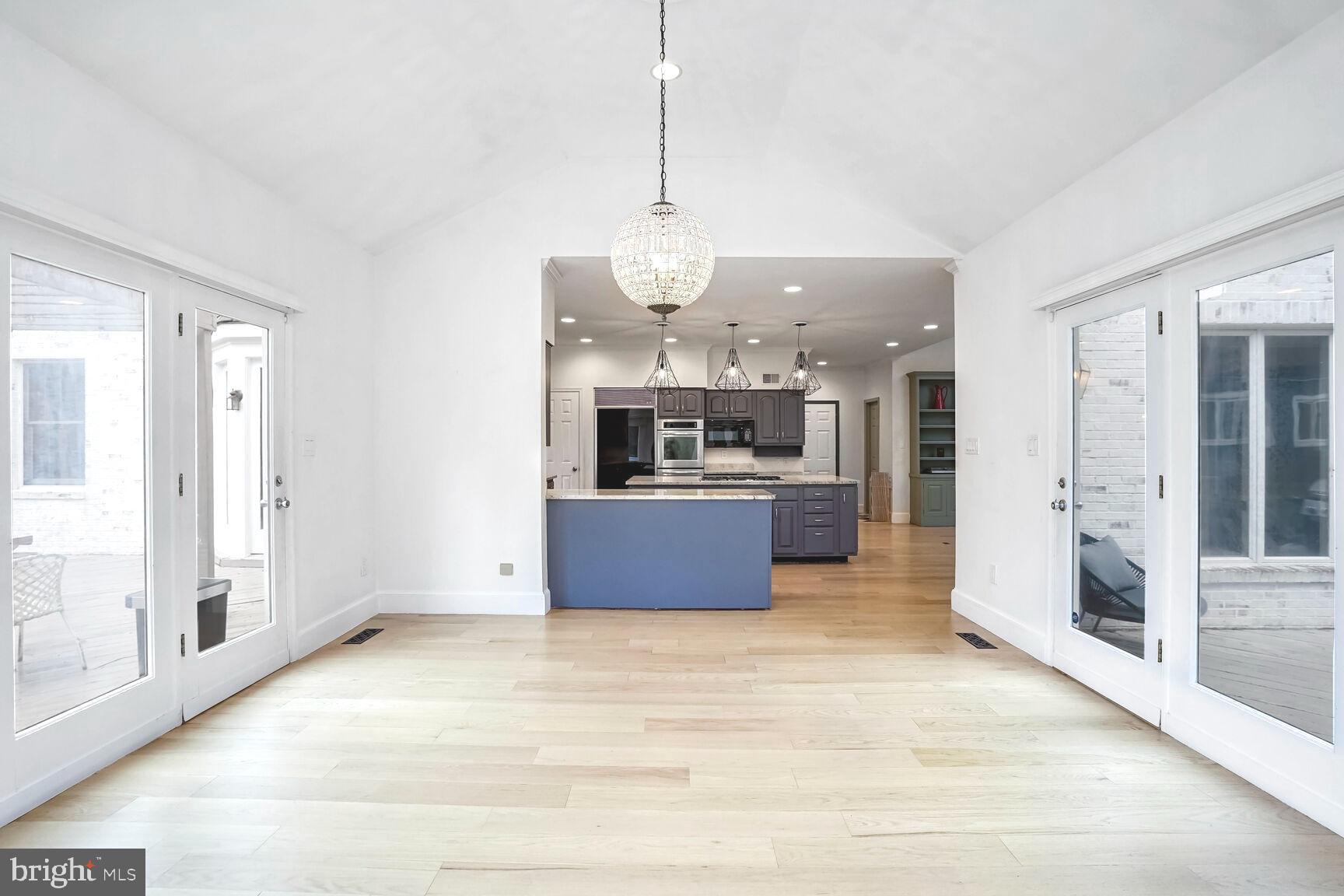 1222 Ranleigh Road McLean, VA 22101 - Photo 16 of 49 a large kitchen with stainless steel appliances kitchen island granite countertop a refrigerator a stove a sink and a dining table with wooden floor