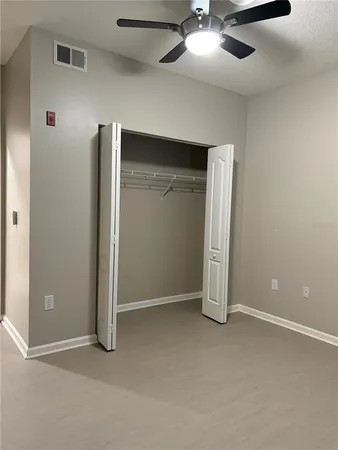 an empty room with chandelier fan