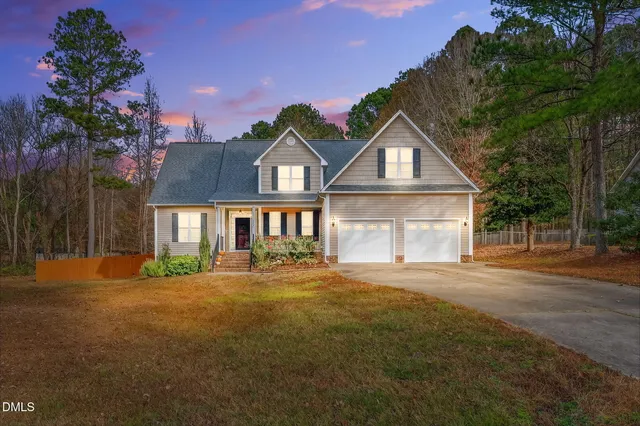 a front view of a house with a yard and trees