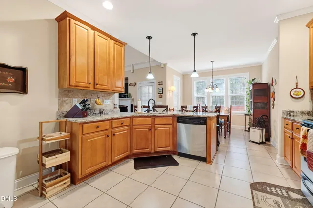 a kitchen with stainless steel appliances granite countertop a stove a sink and white cabinets with wooden floor