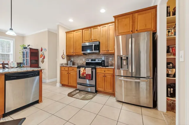 a kitchen with stainless steel appliances granite countertop a refrigerator a stove and a sink
