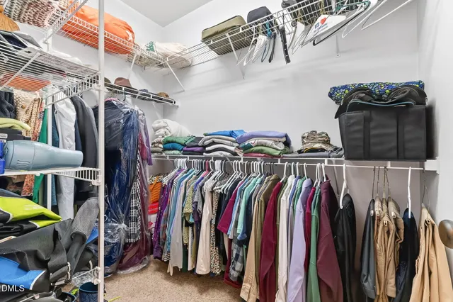 a view of walk in closet with clothes and shoes