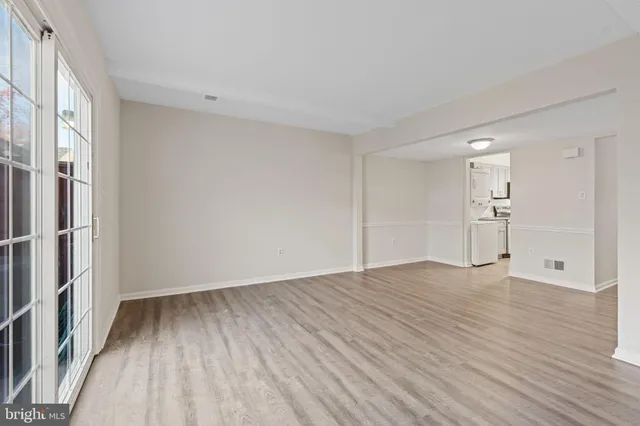 a view of empty room with wooden floor and window