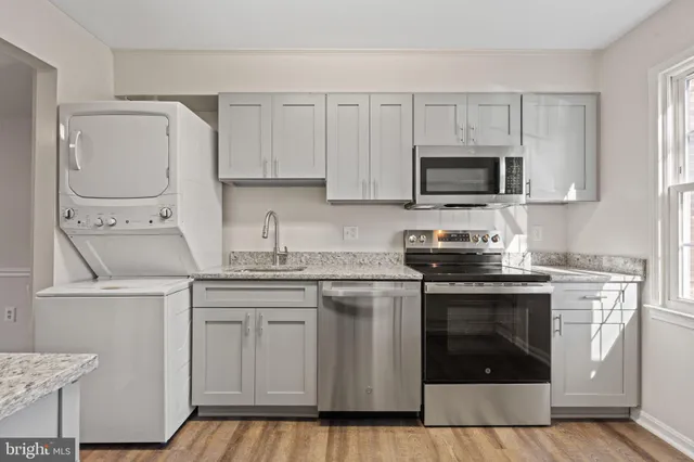 a kitchen with cabinets stainless steel appliances and a sink