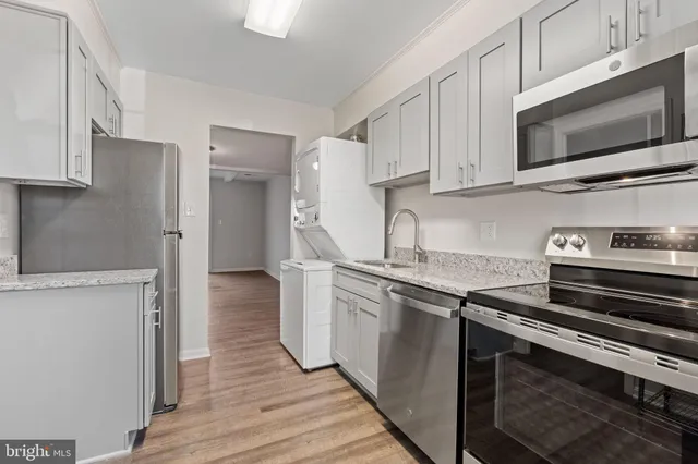 a kitchen with stainless steel appliances a stove microwave and sink