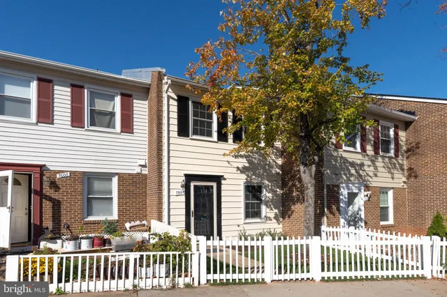 a front view of a house with a tree