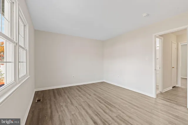wooden floor in an empty room with a window