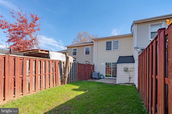 a view of a house with backyard and wooden fence
