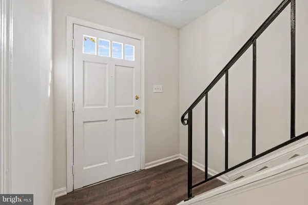 a view of staircase with railing and white walls